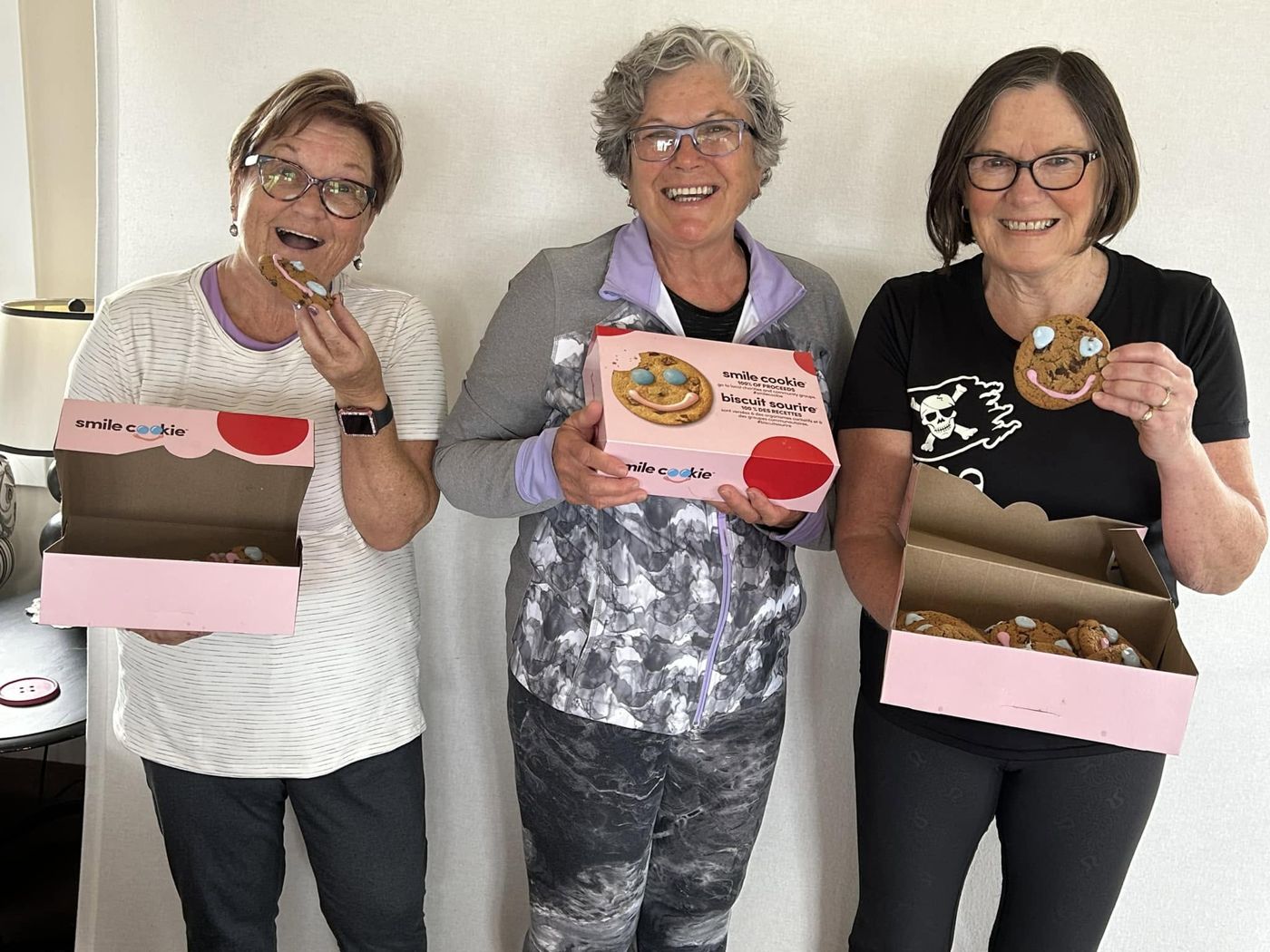 Three women holding up their Smile Cookies
